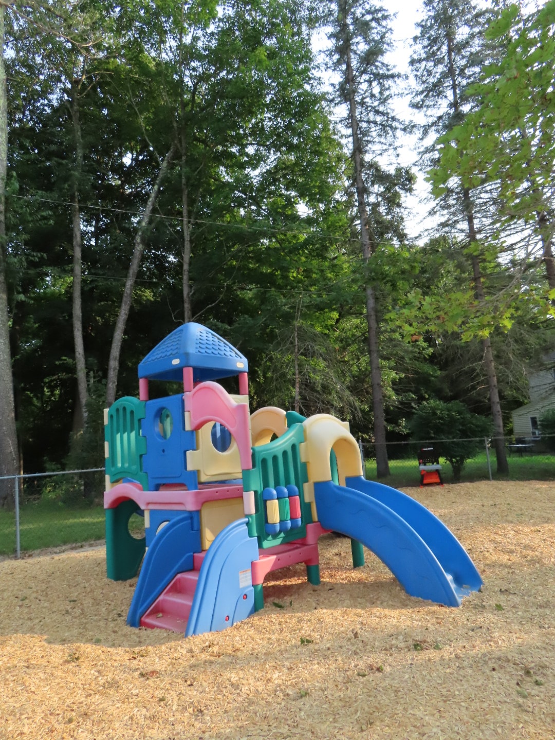 Colorful playground structure in wooded park
