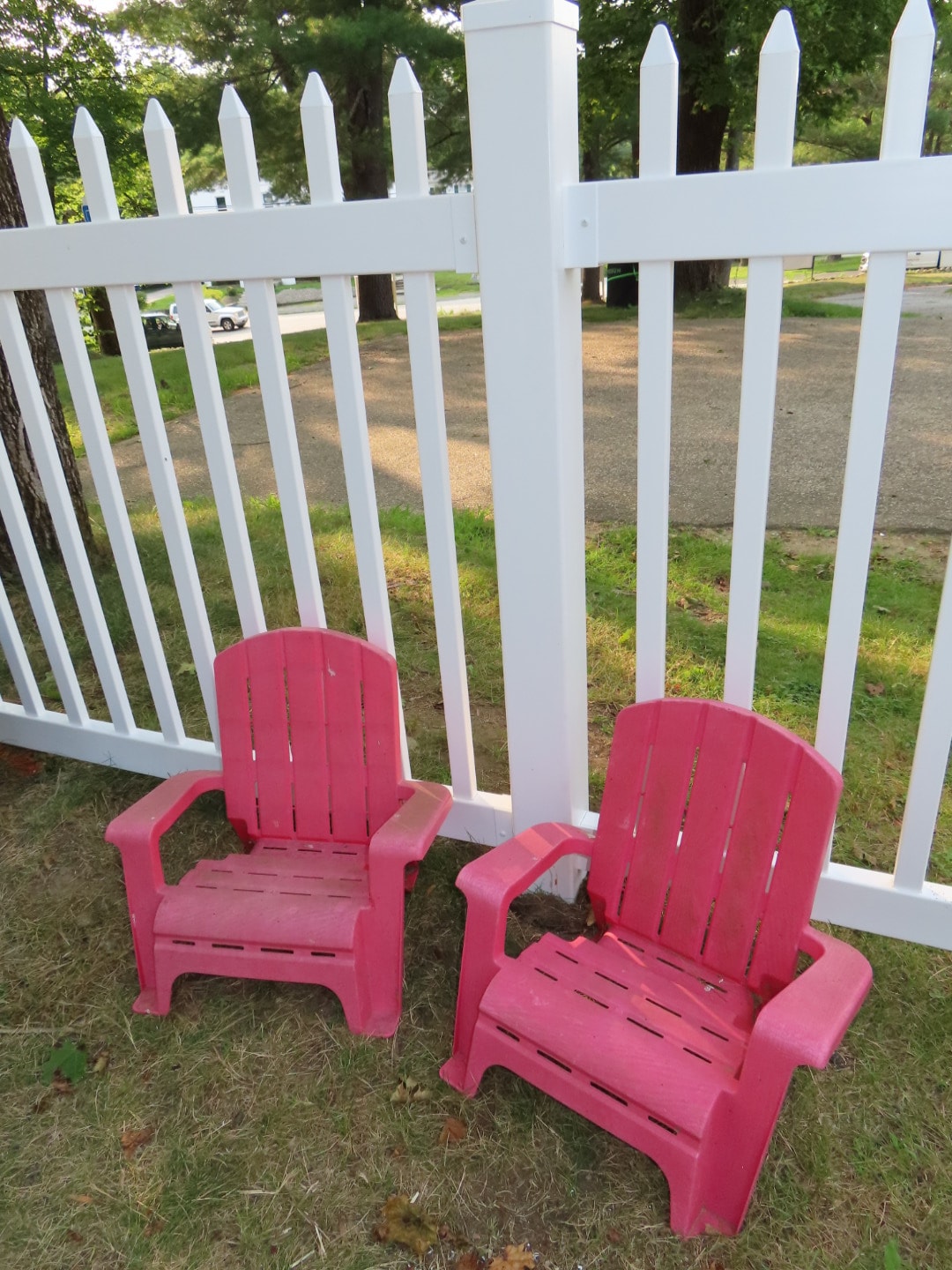 Pink Adirondack chairs with white picket fence